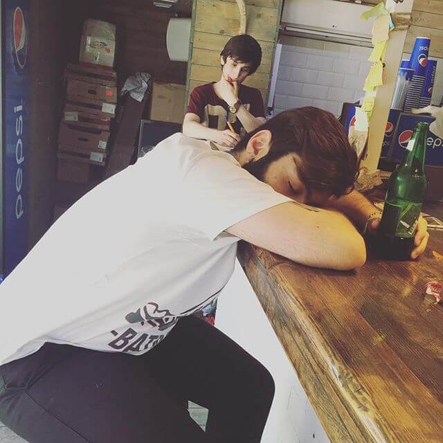 Парень с похмелья лежит на барной стойке Парень с похмелья